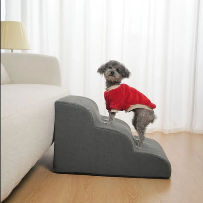 Non slip dog stairs for small dogs with a dog in a red sweater using it by the sofa.
