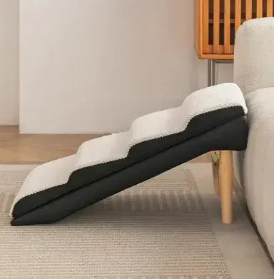 Washable pet stairs for dogs and cats with a modern design leaning against a sofa.