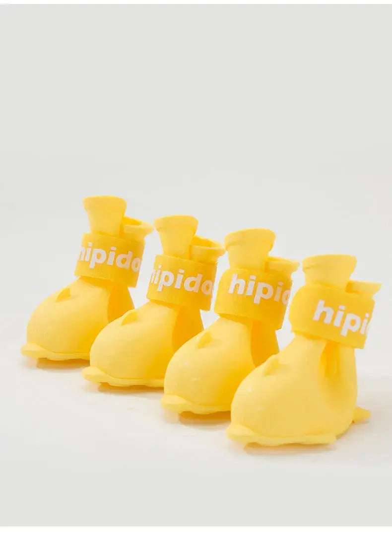 Four yellow waterproof dog boots designed for pets, featuring anti-slip rubber soles and adjustable bands.
